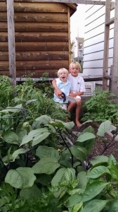 Layton (2) and brother William (8) hanging in the veggie garden